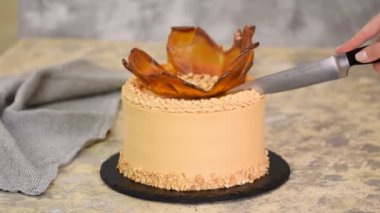 Kadın elleri lezzetli karamelli fındıklı kek kesiyor..