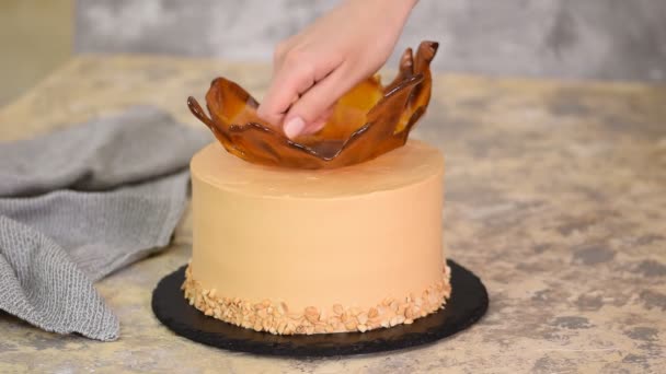 Ο σεφ ζαχαροπλαστικής διακοσμεί το κέικ καραμέλας με φιστίκια. — Αρχείο Βίντεο