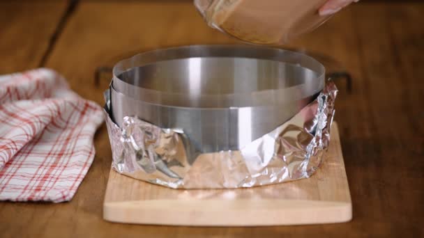 Pastelero vertiendo mousse de chocolate en un anillo de pastelería. — Vídeo de stock
