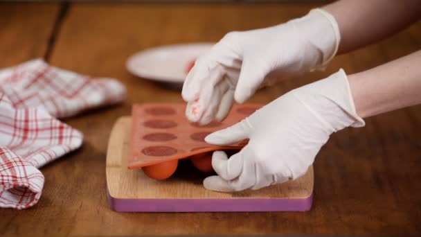 Mãos femininas tirando geleia de morango de um molde de silicone flexível, close-up . — Vídeo de Stock