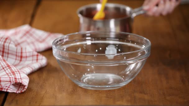 Samičí ruce nalévají jahodové pyré do misky. — Stock video