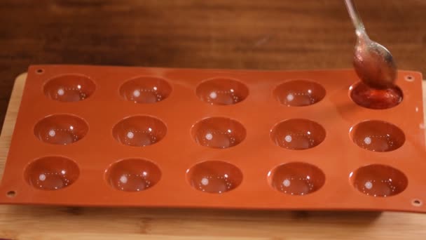 De banketbakker vult de siliconenmal met aardbeienpuree. aardbeiengelei maken. — Stockvideo