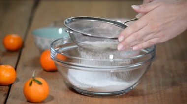 Beyaz unu elemekte olan bir kadın. Ev yapımı..