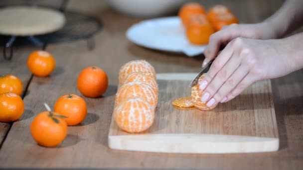 Mulher jovem cortando tangerinas frescas . — Vídeo de Stock