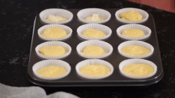 Het vullen van de papiermallen met deeg om muffins te maken. — Stockvideo