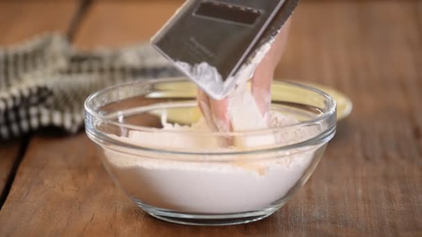 Kuchařka nastrouhaná máslem na bílé mouce v růžové masce. Samičí ruce připravují těsto na pečení. — Stock video