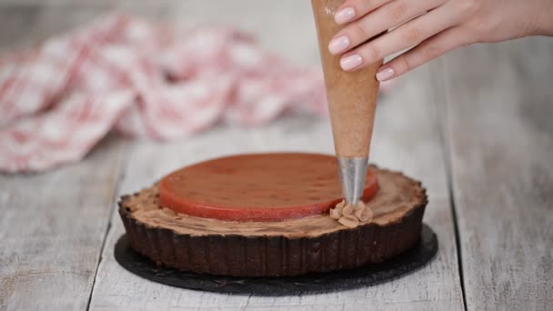 Cukrász díszíti finom csokoládé torta cseresznye confit és csokoládé krém. — Stock videók