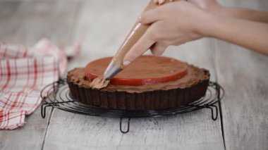 Şekerci lezzetli çikolatalı turtayı kiraz ve çikolata kremalı süsledi..