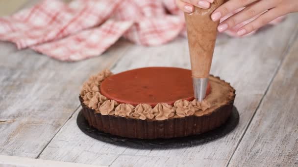 Pastelero decora deliciosa tarta de chocolate con confit de cereza y crema de chocolate . — Vídeos de Stock