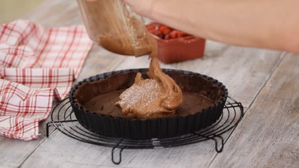 El chef de pastelería hace pastel de almendras de chocolate con crema de almendras. Verter la masa de chocolate en el molde de tarta . — Vídeo de stock