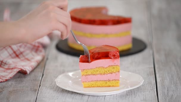 Їжте шматочок торта з ванільним печивом, малиновим мусом і желе, солодкою випічкою . — стокове відео