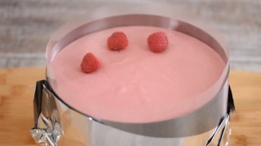 Şekerci pastanın üstüne taze ahududu koyar. Ahududulu kremalı pasta yapıyorum..