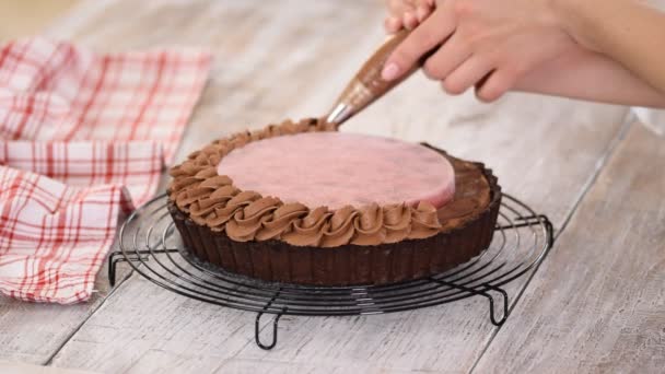 Pastelero decora deliciosa tarta de chocolate con confit de cereza y crema de chocolate . — Vídeos de Stock