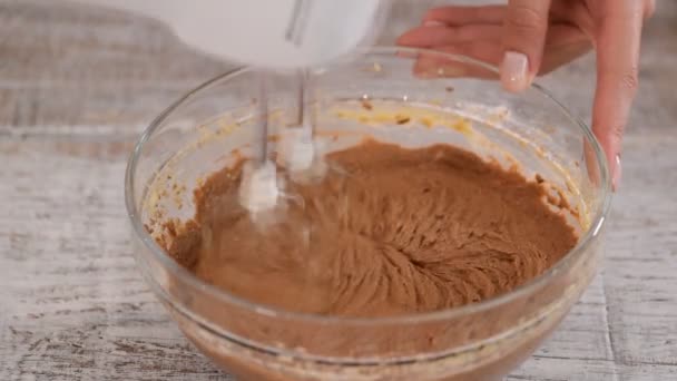 Schlagsahne mit einem Mixer aus Butter und Schokolade. Für den Kuchen braune Schokoladencreme herstellen. Nahaufnahme — Stockvideo