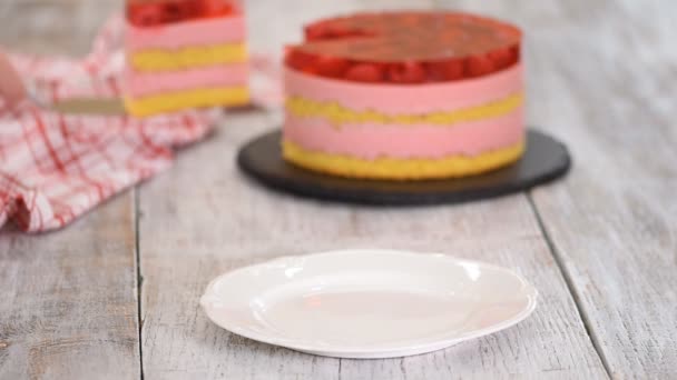 Pièce de gâteau avec biscuit à la vanille, mousse de framboise et gelée, pâtisseries sucrées . — Video