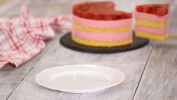 Pièce de gâteau avec biscuit à la vanille, mousse de framboise et gelée, pâtisseries sucrées . — Video