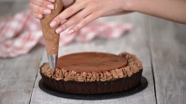 Confiseur décore délicieuse tarte au chocolat avec confit de cerise et crème au chocolat . — Video