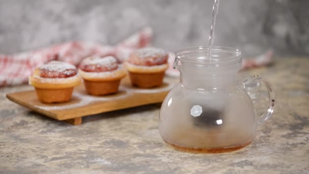 Pouring hot water from a pan into a glass teapot. The process of brewing tea. — Stock Video