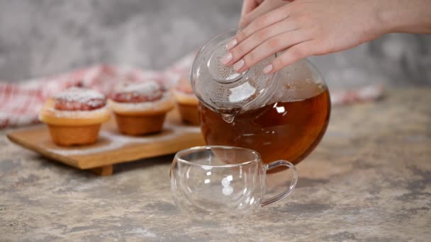 Налийте гарячий чай у склянку. Чашка чаю з трояндами булочки, солодкі булочки з цукровим порошком . — стокове відео