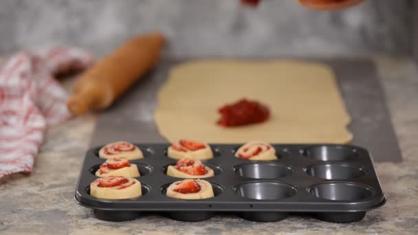 Vrouwelijke handen maken broodjes met bessenjam. — Stockvideo