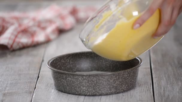 Verser la pâte dans la casserole préparée. Mélange de gâteaux jaunes gros plan . — Video