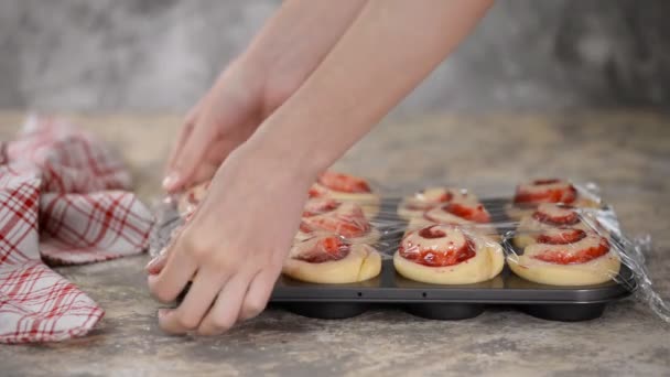 Manos femeninas haciendo bollos de levadura con mermelada de bayas . — Vídeos de Stock