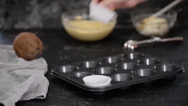 Vrouwelijke handen zet een wit papier cupcake aan de vorm. — Stockvideo