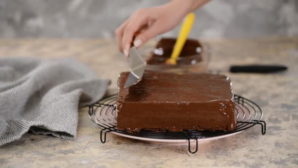 El pastelero esmalta un pastel . — Vídeo de stock