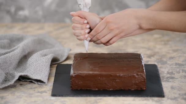 Udekoruj ciasto czekoladą. Przygotowanie deserów w kuchni, produkcja wyrobów cukierniczych w domu. — Wideo stockowe