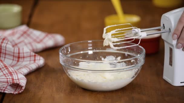 Hausfrau macht selbst gebackenen Kuchen. Weiße Schokolade zur Sahne hinzufügen. — Stockvideo