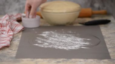 Hamurla çalışan bir kadın. Bir iş yüzeyine maya hamuru koymak.