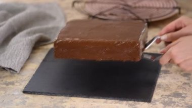 Aşçı kek tabağına çikolatalı pasta koyuyor..