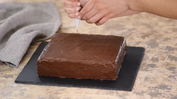 Dekorera tårtan med choklad. Beredning av desserter i köket, tillverkning av konfektyrer i hemmet. — Stockvideo