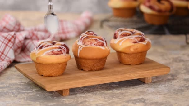 Pouring icing over swirl buns with jam. — Stock Video