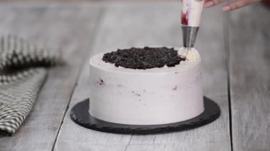 Pastayı pasta poşetinden beyaz kremayla süsleyin. Mutfakta tatlıların hazırlanması, evde şekerleme üretimi..