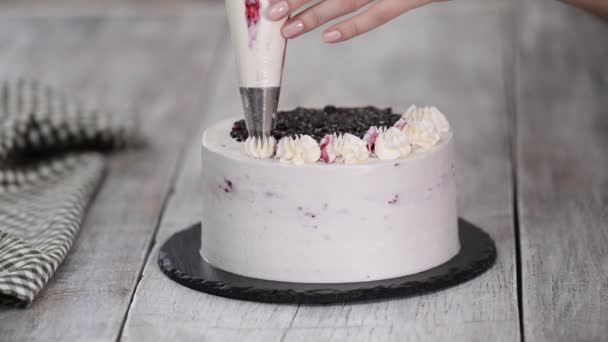 Διακοσμήστε το κέικ από τη σακούλα ζαχαροπλαστικής με λευκή κρέμα. Προετοιμασία γλυκών στην κουζίνα, παραγωγή γλυκισμάτων στο σπίτι. — Αρχείο Βίντεο
