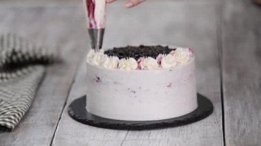 Pastayı pasta poşetinden beyaz kremayla süsleyin. Mutfakta tatlıların hazırlanması, evde şekerleme üretimi..