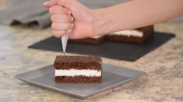 Versier de taart met chocolade. Bereiding van desserts in de keuken, productie van zoetwaren thuis. — Stockvideo