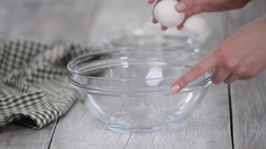 Dişi eller yumurta kırıyor ve sarısını beyazdan ayırıyor..