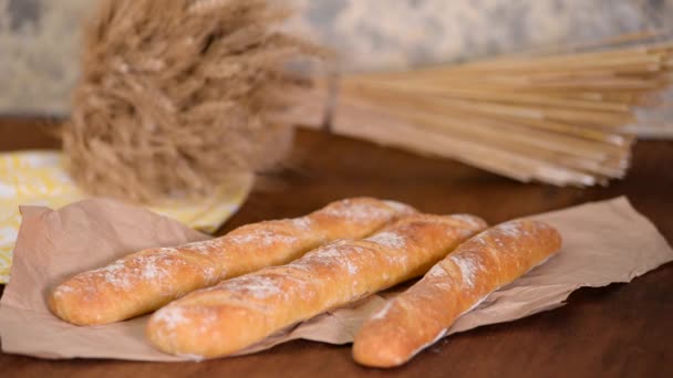 Megtörni egy bagettet. Női kezek, ahogy kettétörik a sült kenyeret. Női kéz törés ropogós francia baguette — Stock videók