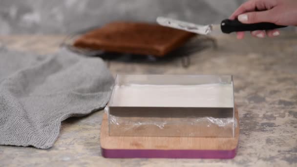 Mujer está preparando pastel de chocolate con crema de leche. El proceso de hacer el pastel de chocolate . — Vídeos de Stock