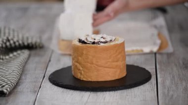 Pasta şefi dikey katmanlı ve kuşüzümü reçelli kek yapıyor. Seri.