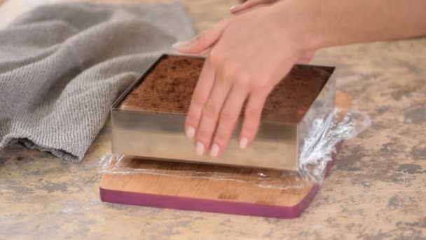 Hände entfernen Metallform von Schokoladenkuchen. — Stockvideo