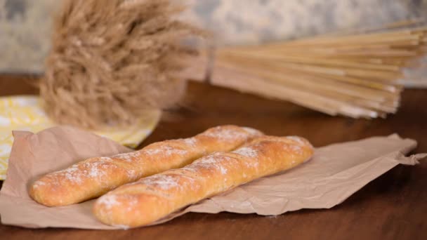 Freshly baked French baguettes on wooden table. — Stock Video