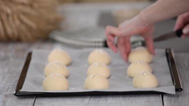 Kadın ev yapımı kahvaltı çörekleri yapıyor. Çörek yapıyorum. Pişirme tepsisinde gübre.