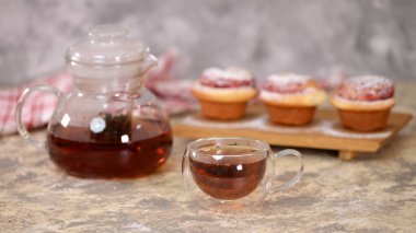 Güllü çöreklerle bir fincan çay, şekerli çörekler.