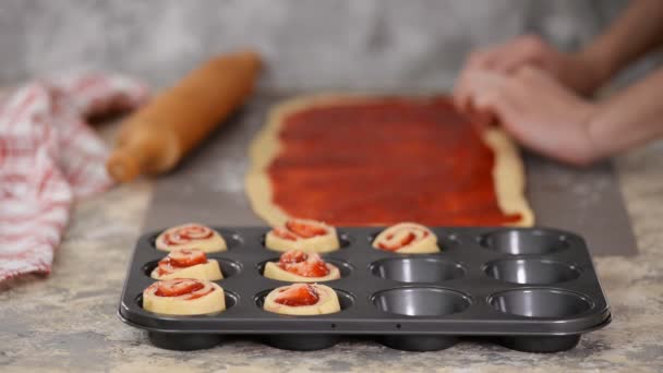 Vrouwelijke handen maken broodjes met bessenjam. — Stockvideo