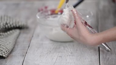 Kadın hamur çantasını kremayla dolduruyor..