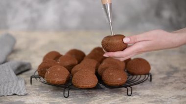 Çikolatalı profiterolleri kremayla dolduran bir şef..
