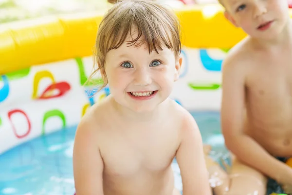 小さな子供たちは 夏の暑い日に黄色インフレータブル スイミング子供用プールでを屋外入浴します プールでの子供たち — ストック写真